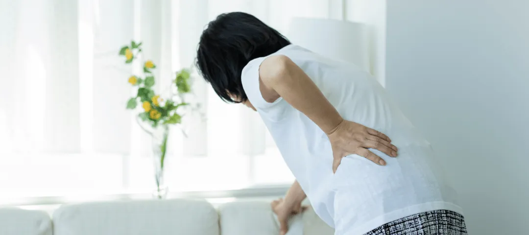 腰を押さえている女性の画像