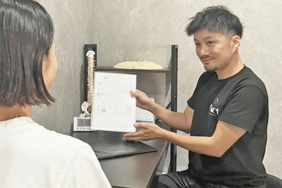 女性に注意点を説明する整体師