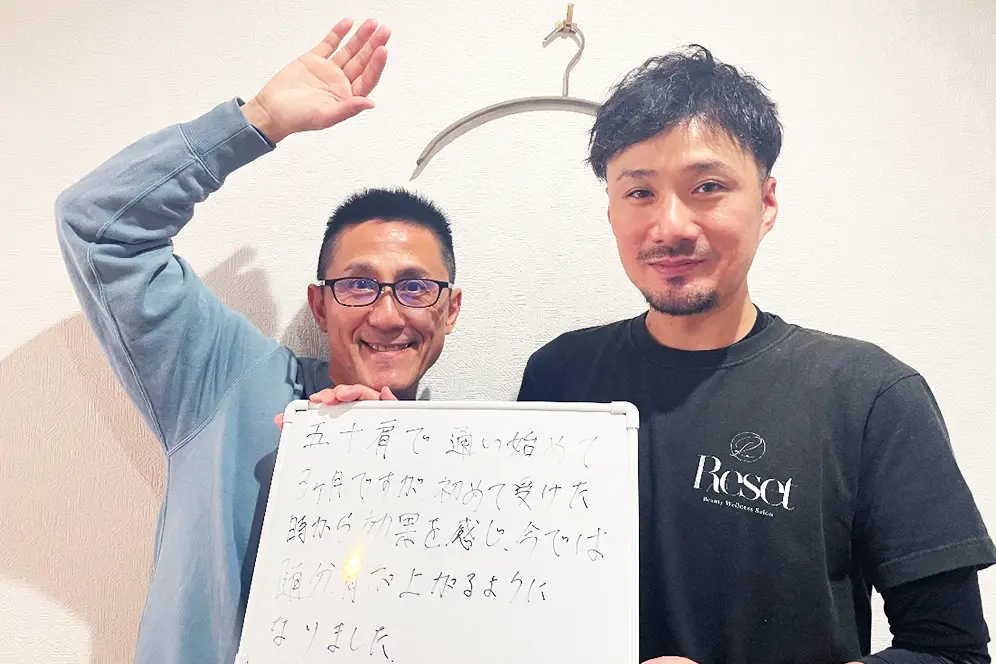 症状が改善した患者と並ぶ整体師