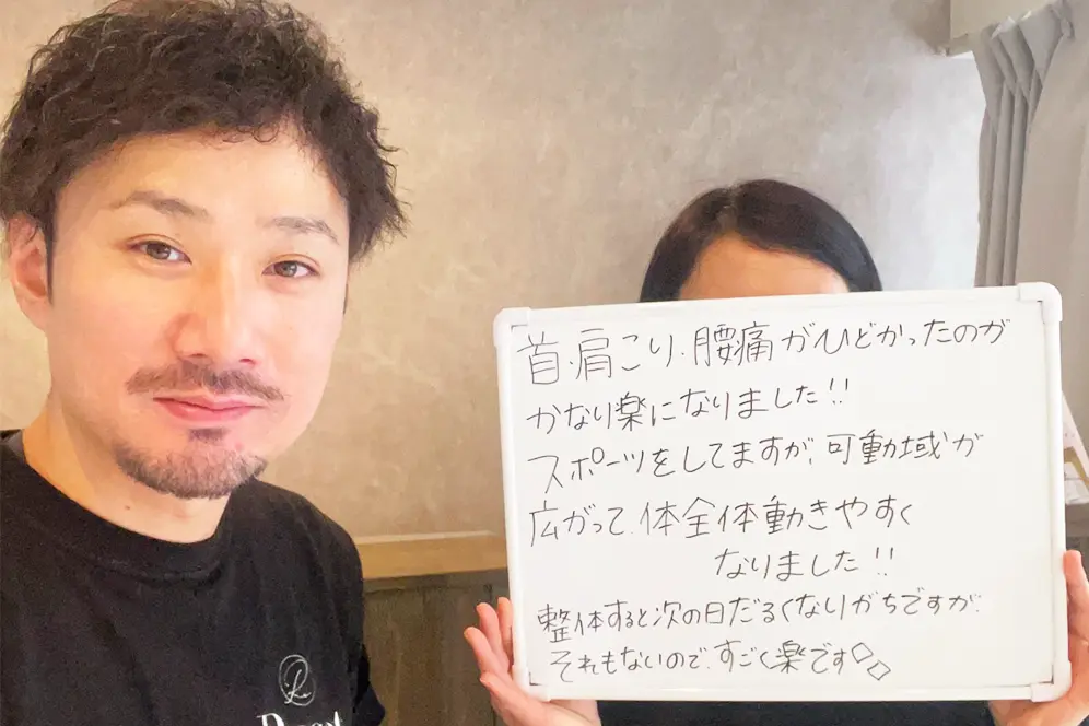 症状が改善した患者と並ぶ整体師